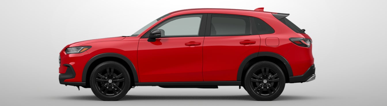 Exterior side view of a 2027 HR-V in Milano Red parked agaisnt a light gray background