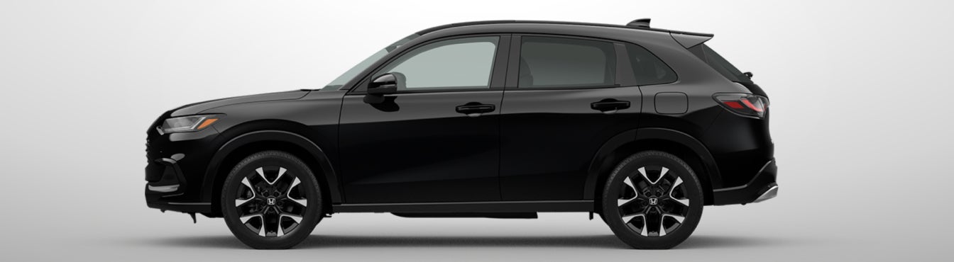 Exterior side view of a 2027 HR-V in Crystal Black Pearl parked agaisnt a light gray background