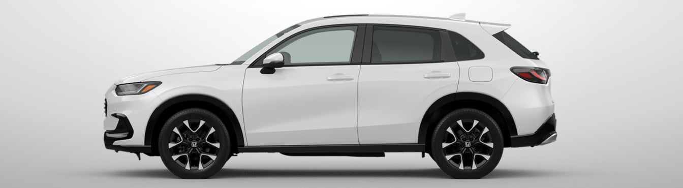 Exterior side view of a 2027 HR-V in Platinum White Pearl parked agaisnt a light gray background