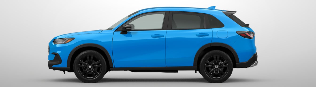 Exterior side view of a 2027 HR-V in Boost Blue Pearl parked agaisnt a light gray background
