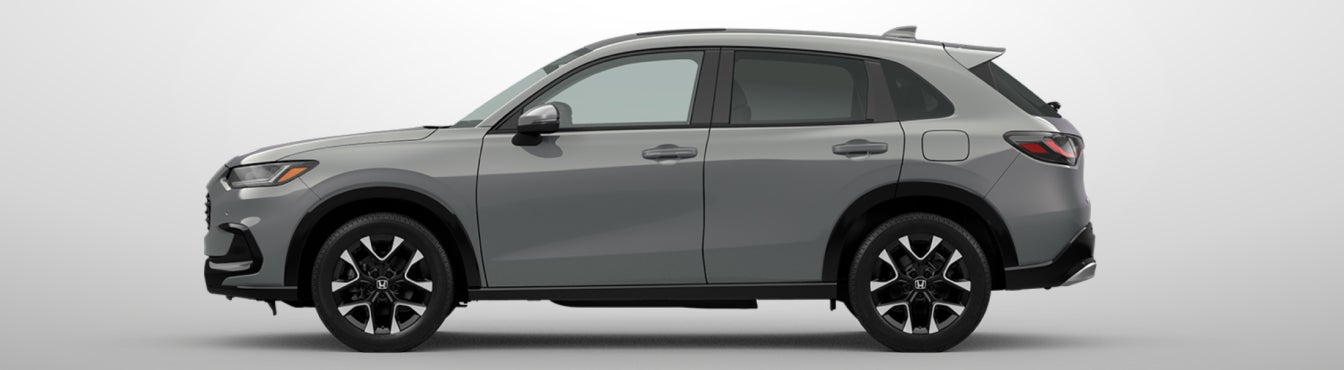 Exterior side view of a 2027 HR-V in Urban Gray Pearl parked agaisnt a light gray background
