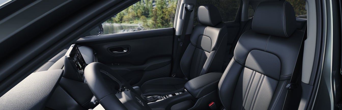 Perspective shot of 2027 Honda HR-V interior in black leather seen from outside the front driver side window.