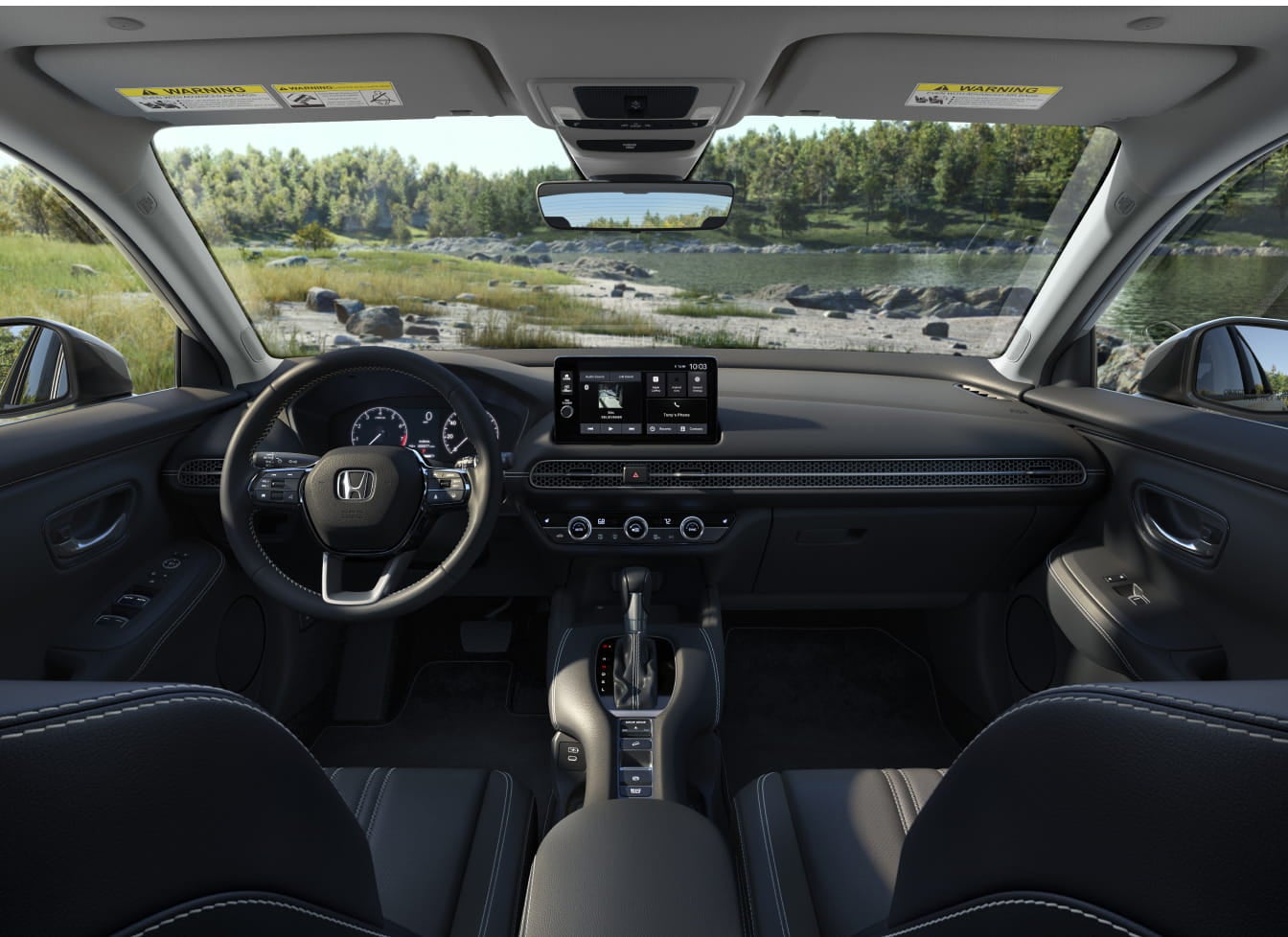 HR-V interior with black leather seats, modern dashboard featuring a touchscreen display, and a steering wheel with a scenic lake view through the windshield.