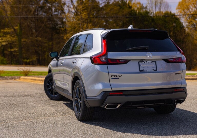 Back view of a 2026 Honda CR-V Hybrid parked. The hybrid SUV is silver